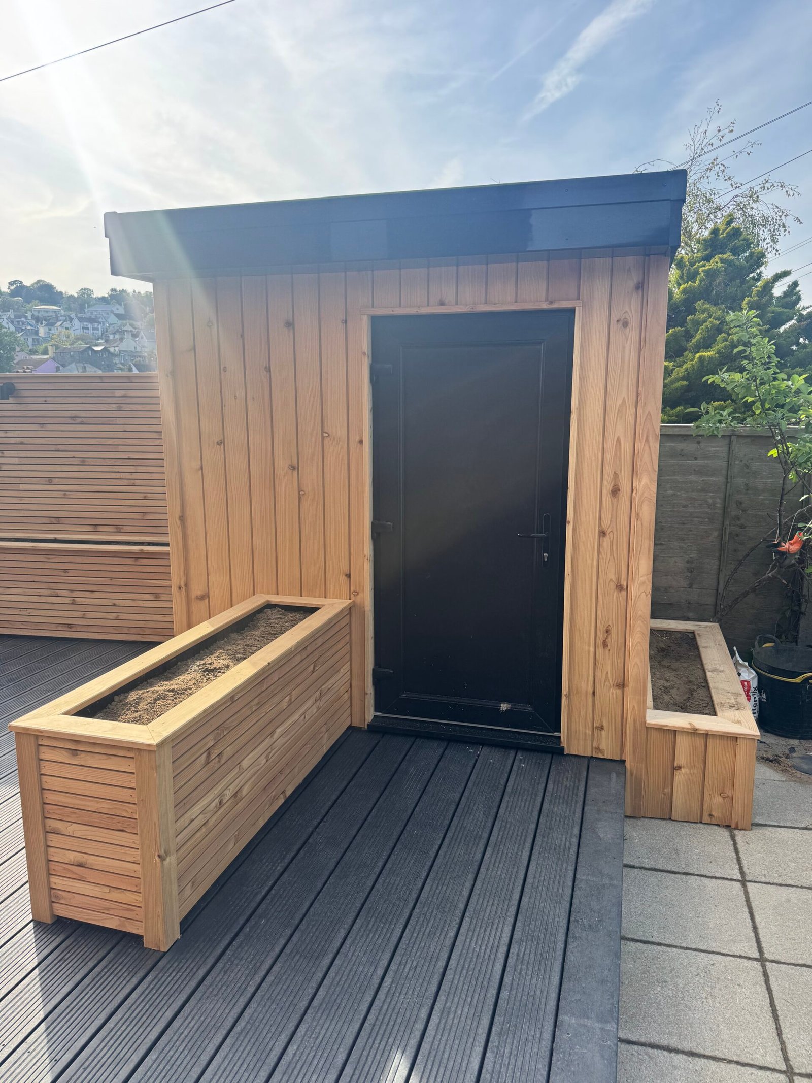 Timber garden structure with matching planters and dark decking