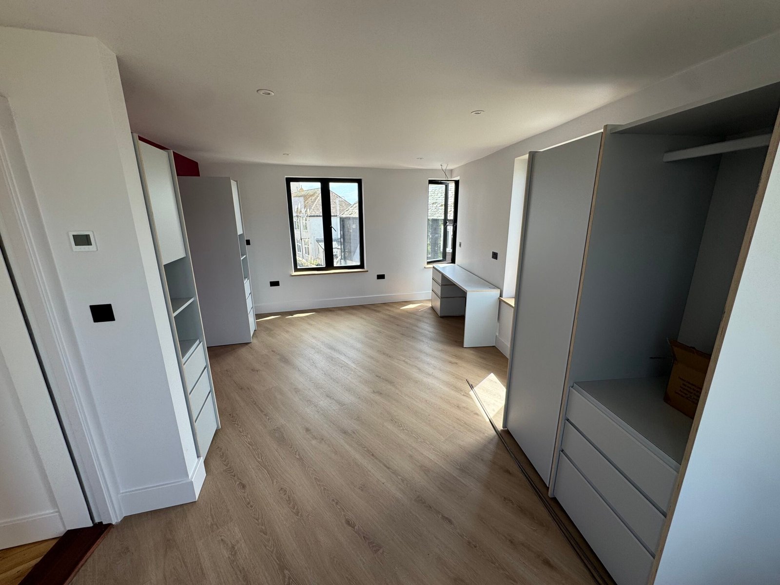 Bright renovated living space with pale timber-effect flooring at Rusty Towers