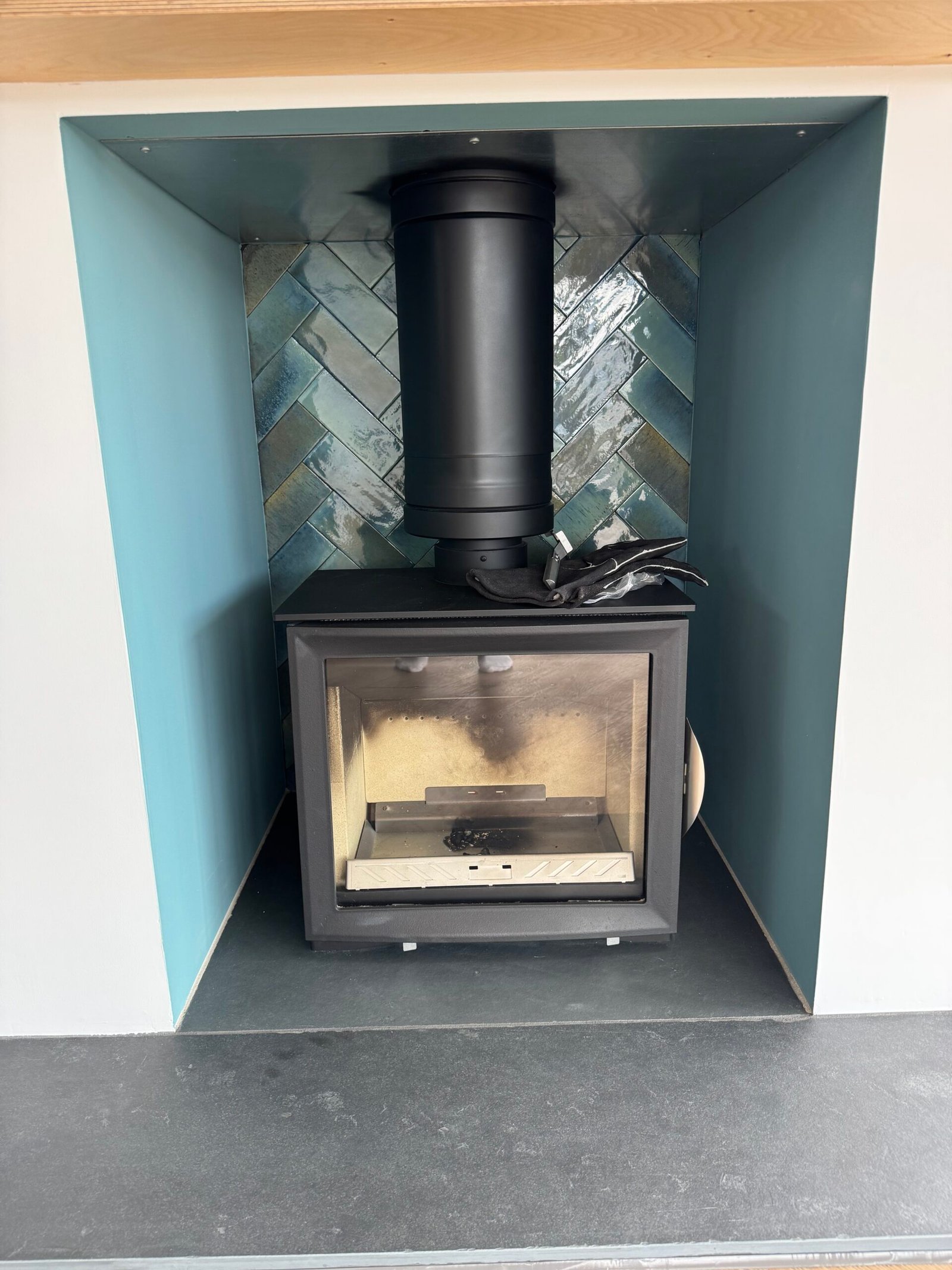 Wood-burning stove set within a blue tiled alcove