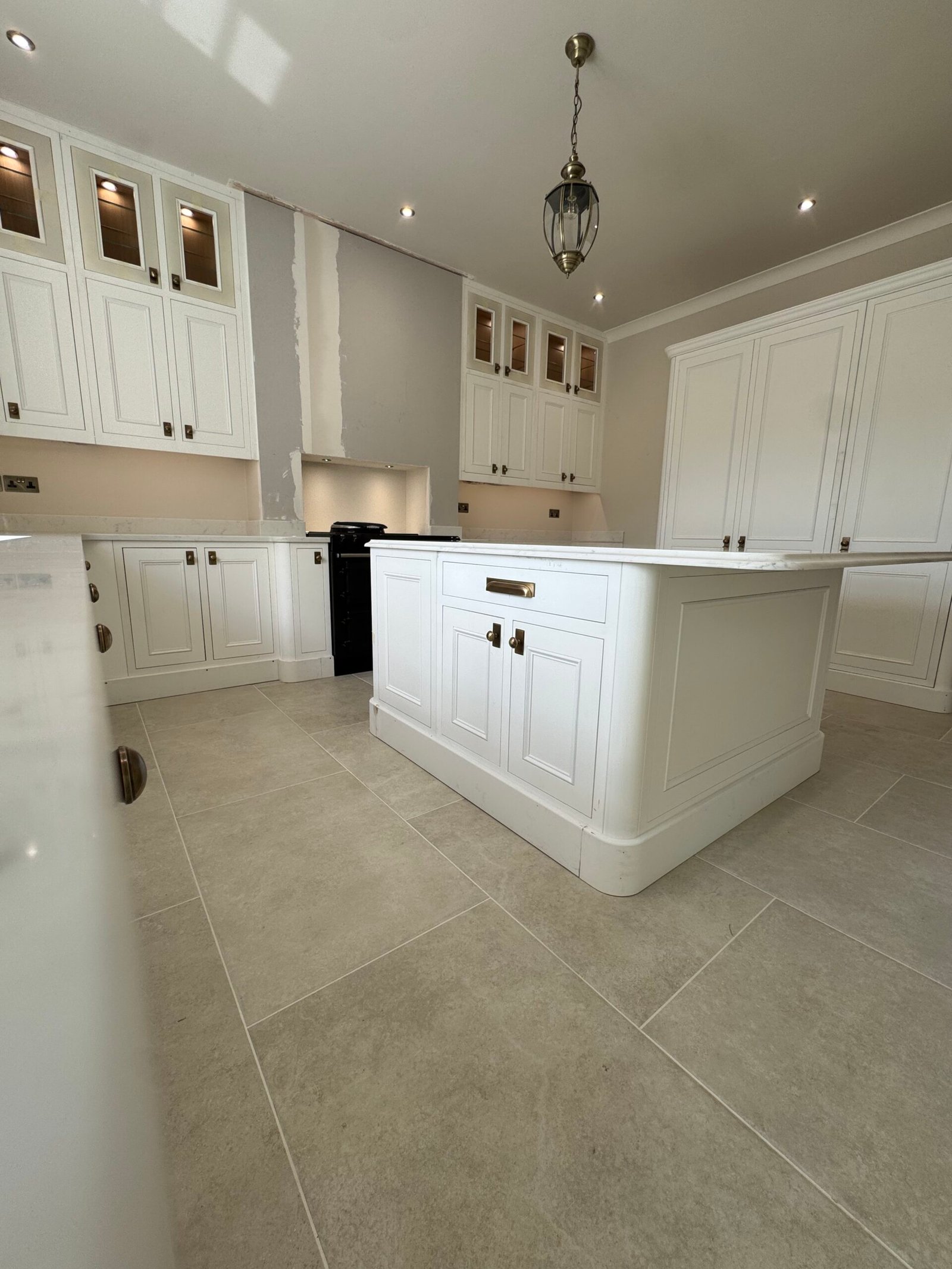 Complete kitchen renovation featuring bespoke-style cabinetry, a central island and new tiled flooring.