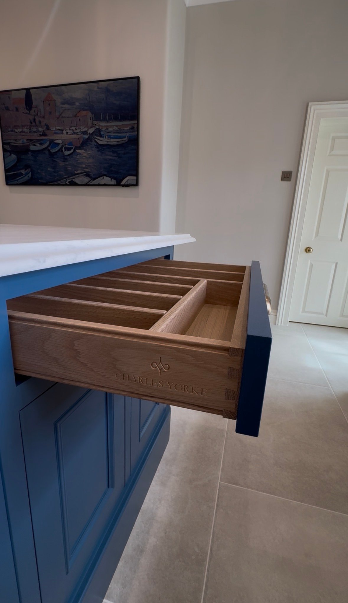 Close-up of bespoke-style kitchen island drawer with timber compartments and branded joinery detail